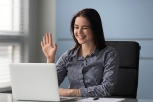 female waving a recruiter on laptop during virtual interview